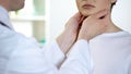 Male physician checking patient throat and neck, health examination in hospital