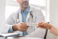 Male physician consulting female patient about pills, prescribing medicine, sitting at desk in clinic office, closeup Royalty Free Stock Photo