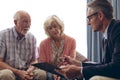 Male physician interacting with senior couple at retirement home Royalty Free Stock Photo