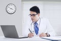Male physician with notebook in office