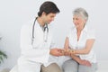 Male physiotherapist examining a senior womans wrist