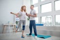 Male physiotherapist helping female patient keep balance