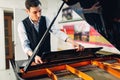 Male pianist opens the lid of black grand piano Royalty Free Stock Photo