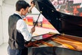 Male pianist opens the lid of black grand piano Royalty Free Stock Photo