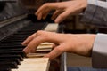 Male pianist playing music on an ivory keyboard