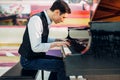 Male pianist practicing composition on grand piano