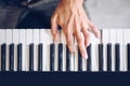 Male pianist`s hand on piano keyboard seen from above