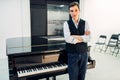 Male pianist stands at the black grand piano Royalty Free Stock Photo