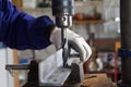 Male piercing an iron piece with a drill in the construction site