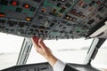 Male pilot turning button on passenger airplane Royalty Free Stock Photo