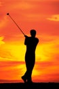 Male playing golf at dawn silhouetted with copy space
