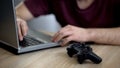 Male playing video games, joystick lying on table near laptop, gaming addiction