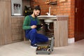 Male plumber with clipboard near kitchen sink Royalty Free Stock Photo