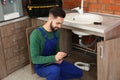 Male plumber with clipboard near kitchen sink Royalty Free Stock Photo