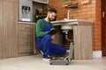 Male plumber with clipboard near kitchen sink Royalty Free Stock Photo