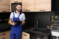 Male plumber with clipboard near kitchen sink Royalty Free Stock Photo