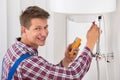 Male Plumber Examining Electric Boiler Royalty Free Stock Photo