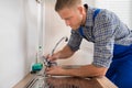 Plumber Fixing Faucet In Kitchen Sink Royalty Free Stock Photo