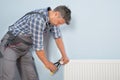 Male plumber fixing radiator Royalty Free Stock Photo