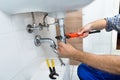 Male plumber fixing sink in bathroom Royalty Free Stock Photo