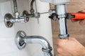 Male plumber fixing sink in bathroom Royalty Free Stock Photo