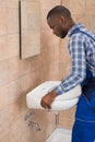 Male Plumber Fixing Sink In Bathroom Royalty Free Stock Photo