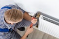 Male Plumber Fixing Thermostat Using Wrench Royalty Free Stock Photo