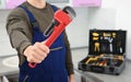 Male plumber holding pipe wrench in kitchen, closeup with. Repair service Royalty Free Stock Photo