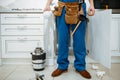 Male plumber installing water filter in kitchen Royalty Free Stock Photo