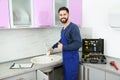 Male plumber in uniform checking faucet. Repair service Royalty Free Stock Photo