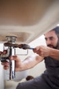 Male Plumber Using Wrench To Fix Leaking Sink In Home Bathroom Royalty Free Stock Photo