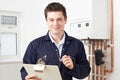 Male Plumber Working On Central Heating Boiler