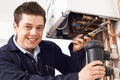 Male Plumber Working On Central Heating Boiler