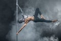 Male pole dancer posing in dark studio