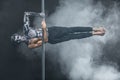 Male pole dancer posing in dark studio Royalty Free Stock Photo