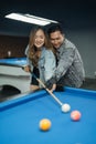 male pool player teaching the female player to poke the white ball Royalty Free Stock Photo