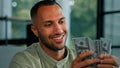 Male portrait happy smiling rich success Latin man counting money African American businessman holding fan of dollars