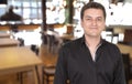 Male portrait of smiling proud owner man standing at his restaurant