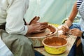 Male potter teaches a child how to mold from clay