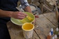 Male potters hand painting a bowl in pottery workshop