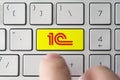 Male presses button on keyboard with the 1C logo. 1C is a Russian company specializing in distribution, support and development of