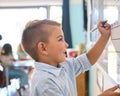 Male Primary Or Elementary School Student Writing On Whiteboard In Classroom Lesson Royalty Free Stock Photo