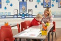 Male Primary School Pupil And Teacher Working