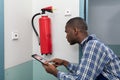Male Professional Checking A Fire Extinguisher Royalty Free Stock Photo