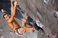 Male professional climber at indoor workout at bouldering centre.