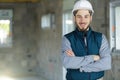 male professional engineer with tool belt posing with crossed arms