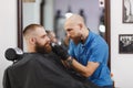 The man barber serves the client in the salon