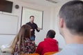 Male professor explain lesson to students and interact with them in the classroom.Helping a students during class. University Royalty Free Stock Photo