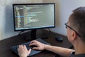 Male programmer working on coding project at computer desk with modern technology setup Royalty Free Stock Photo
