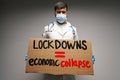 Male protester holding placard against coronavirus lockdowns against grey background Royalty Free Stock Photo